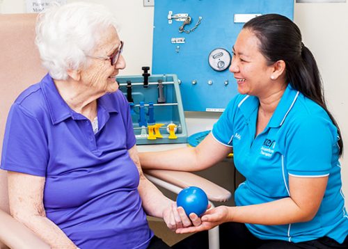 An occupational therapist conducts an exam of a hospital patient