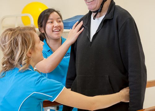 two staff members with a smiling patient