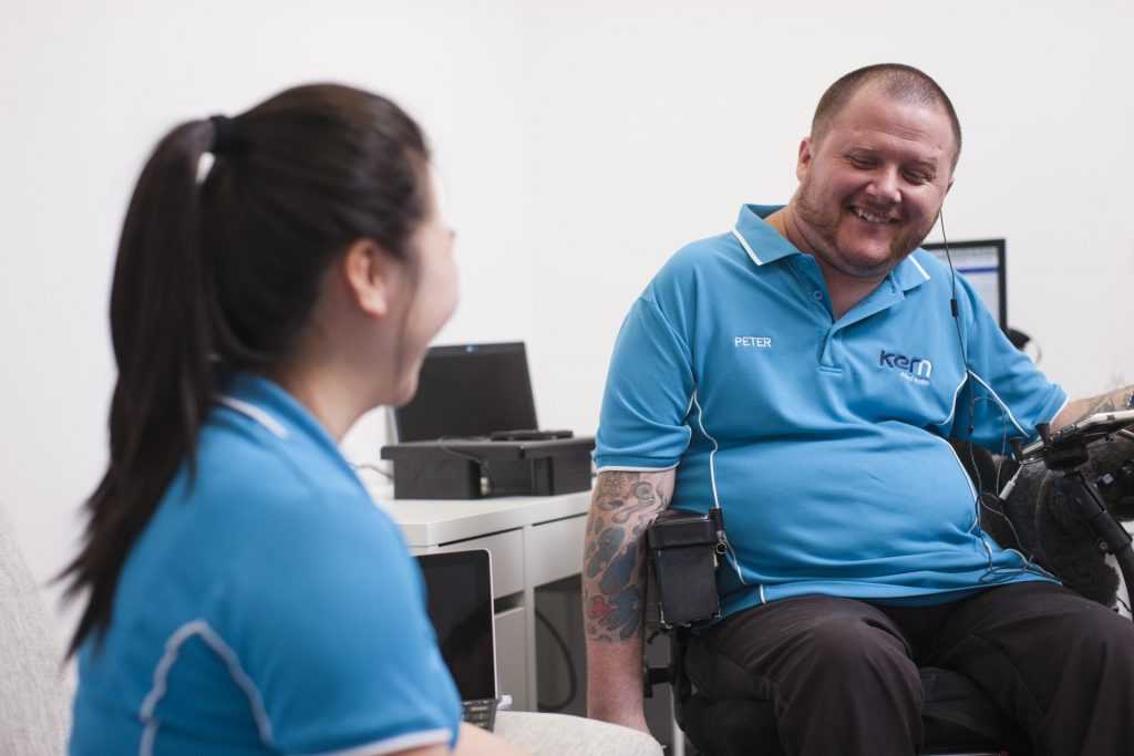 Two Kern Allied Health staff members smile while talking with each other