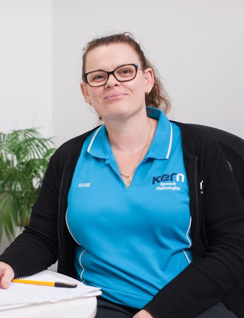 A Kern Allied Health speech pathologist smiles while looking up from her notepad