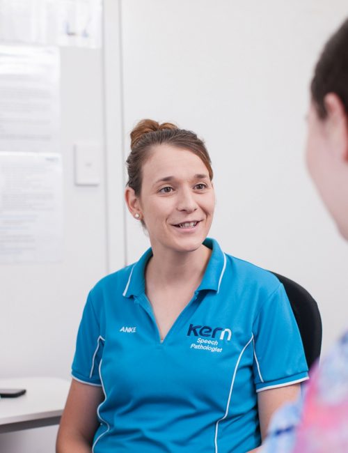 An NDIS speech pathologist talks to a client at the Kern Allied Health clinic